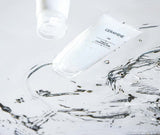 Ceramine Vitamin Cleansing Milk tubes in clear rippling water